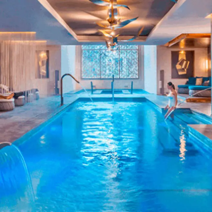 Indoor hydrotherapy spa pool with cascading water features and ambient lighting for ultimate relaxation.