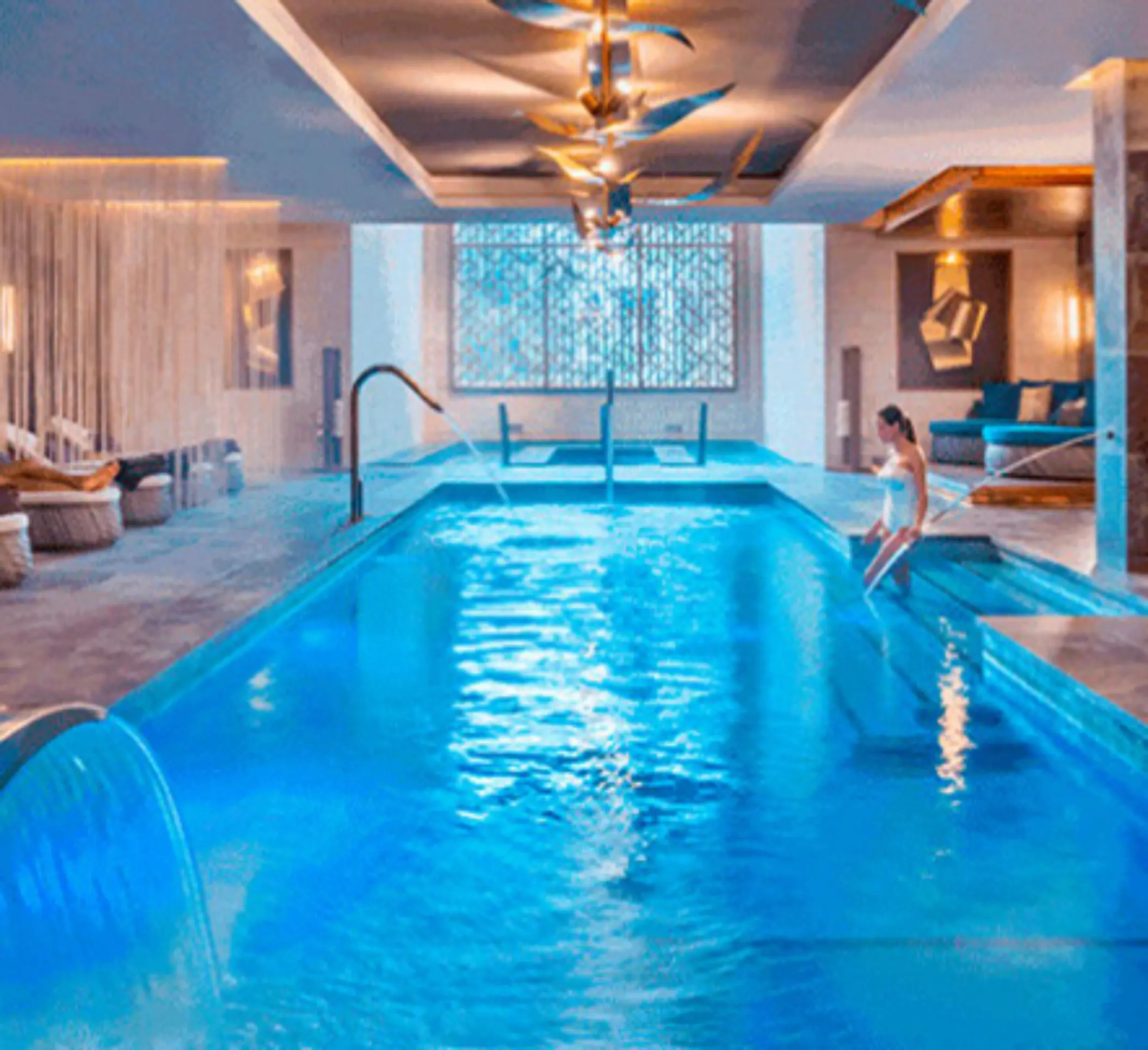 Indoor hydrotherapy spa pool with cascading water features and ambient lighting for ultimate relaxation.