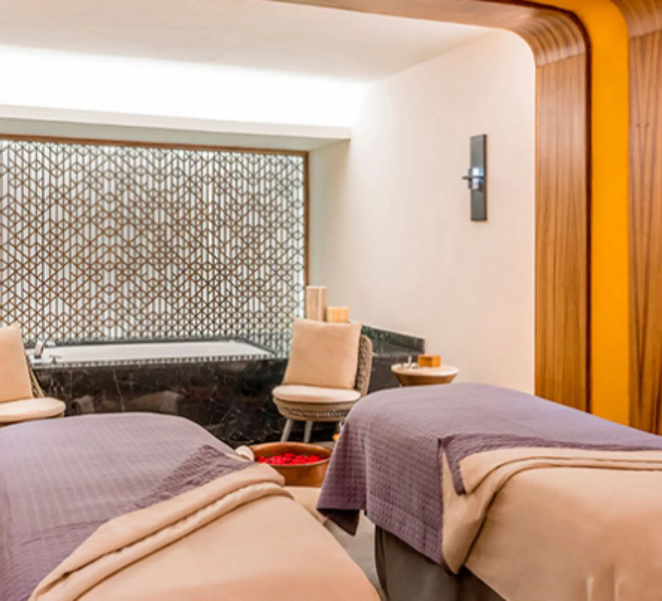 Couples massage room with elegant wood accents and a tranquil setting for a soothing spa session.