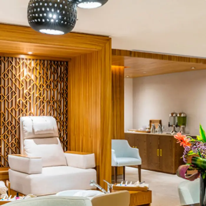 Spa salon area with plush pedicure chairs, wood paneling, and refreshments for a full pampering session.
