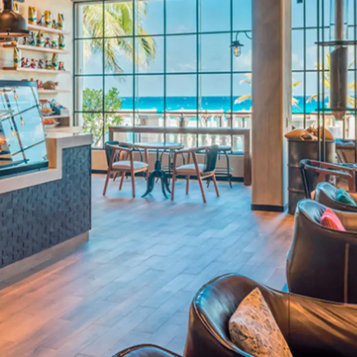 Modern coffee shop with ocean view and cozy seating, ideal for a morning espresso by the beach.