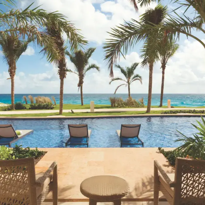 furnished balcony with view of the pool and ocean at the swim up king suite at Hyatt Ziva Cancun