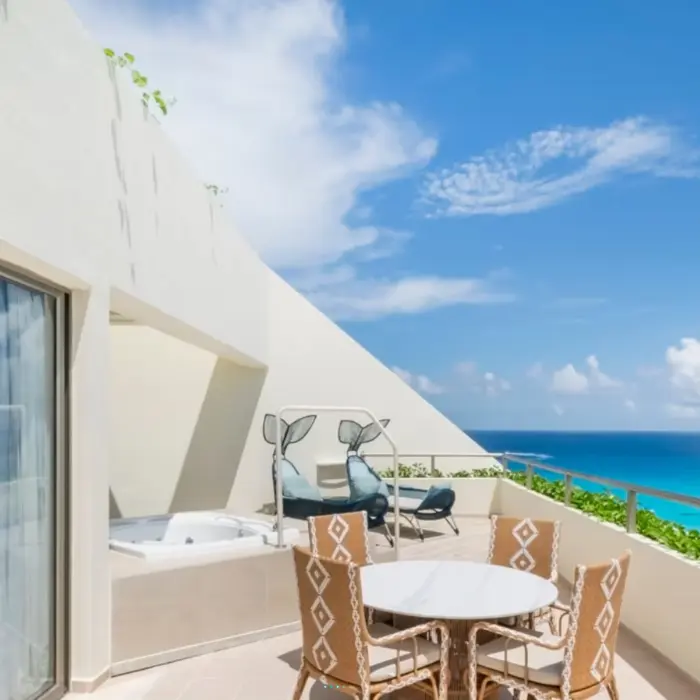 Spacious terrace with hot tub, lounge chairs, dining set, and breathtaking view of turquoise Caribbean waters.