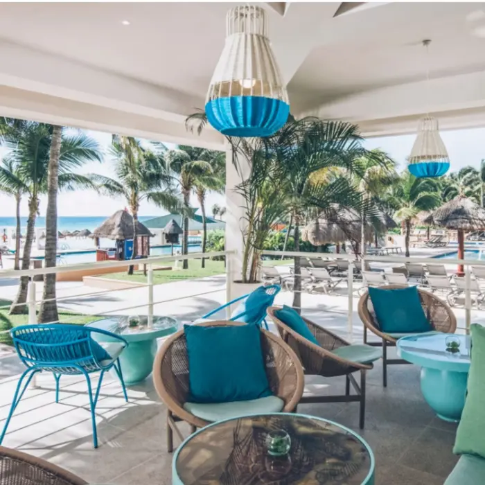 Serene beachfront with hammocks tied between palm trees, soft sand, and turquoise water stretching into the horizon.