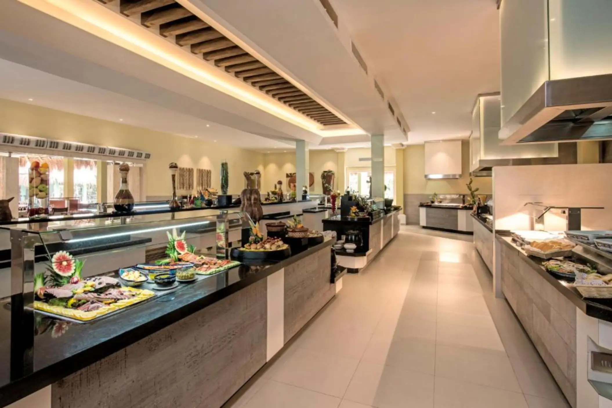 An indoor buffet restaurant with a long counter full of various food options.