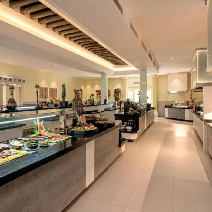 An indoor buffet restaurant with a long counter full of various food options.