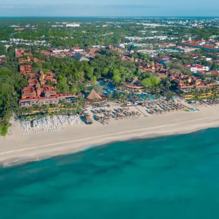 A wide aerial shot of the resort, showing the building roofs and the resort's beachfront.