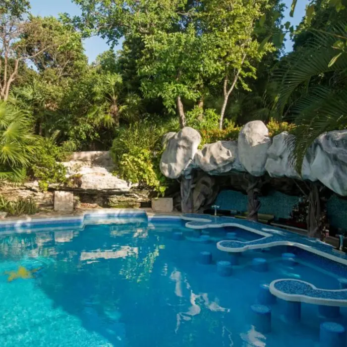 A pool with a swim-up bar and barstools built directly into the water.