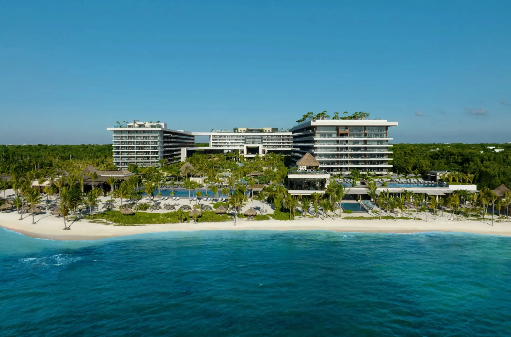 Aerial view of Secrets Impressions Moxché with lush gardens and beachside pools.