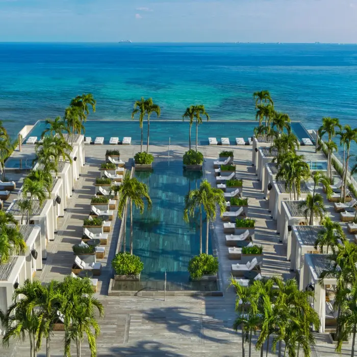 Infinity rooftop pool with ocean backdrop and private cabanas at Secrets Impressions.