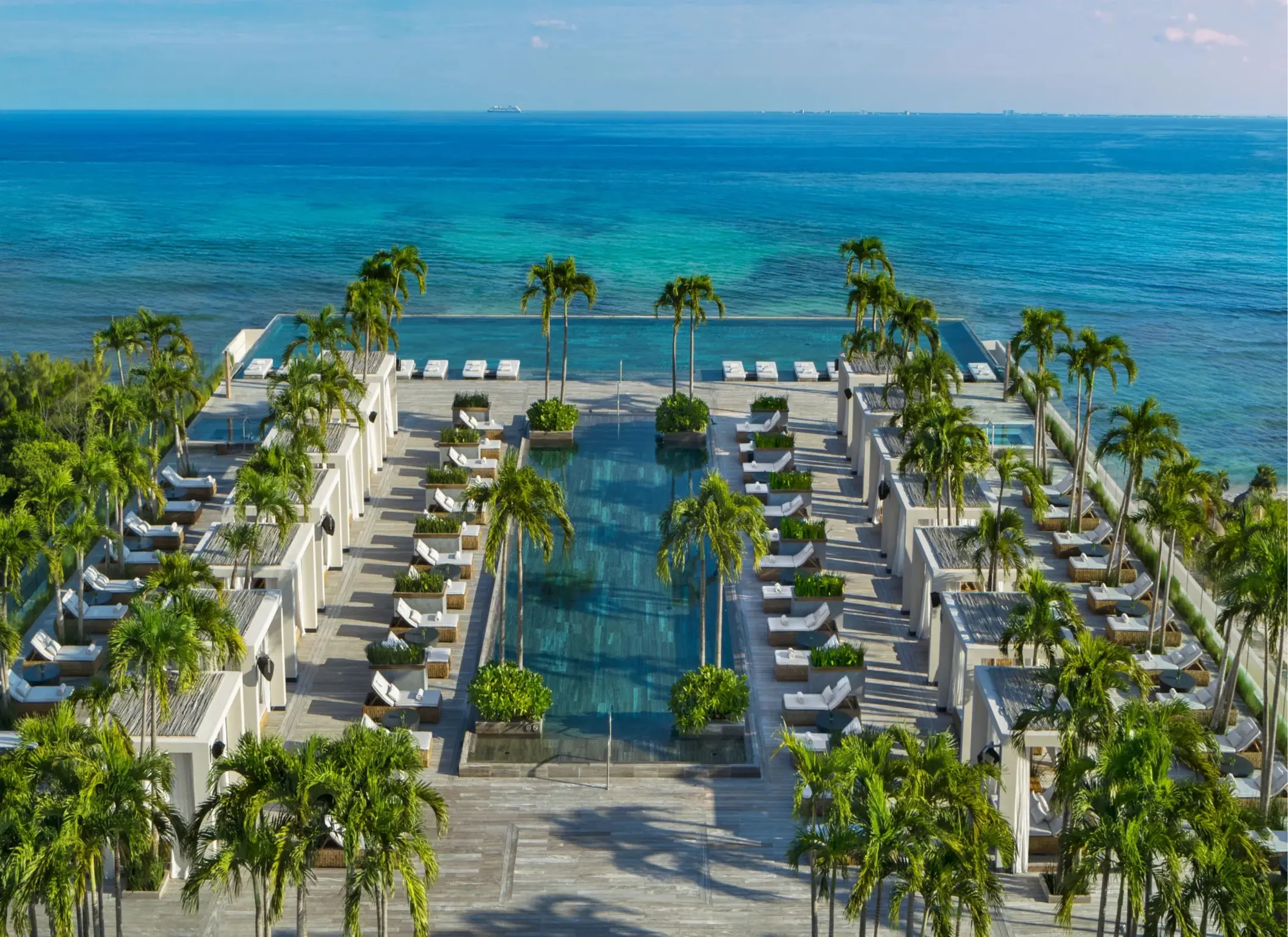Infinity rooftop pool with ocean backdrop and private cabanas at Secrets Impressions.