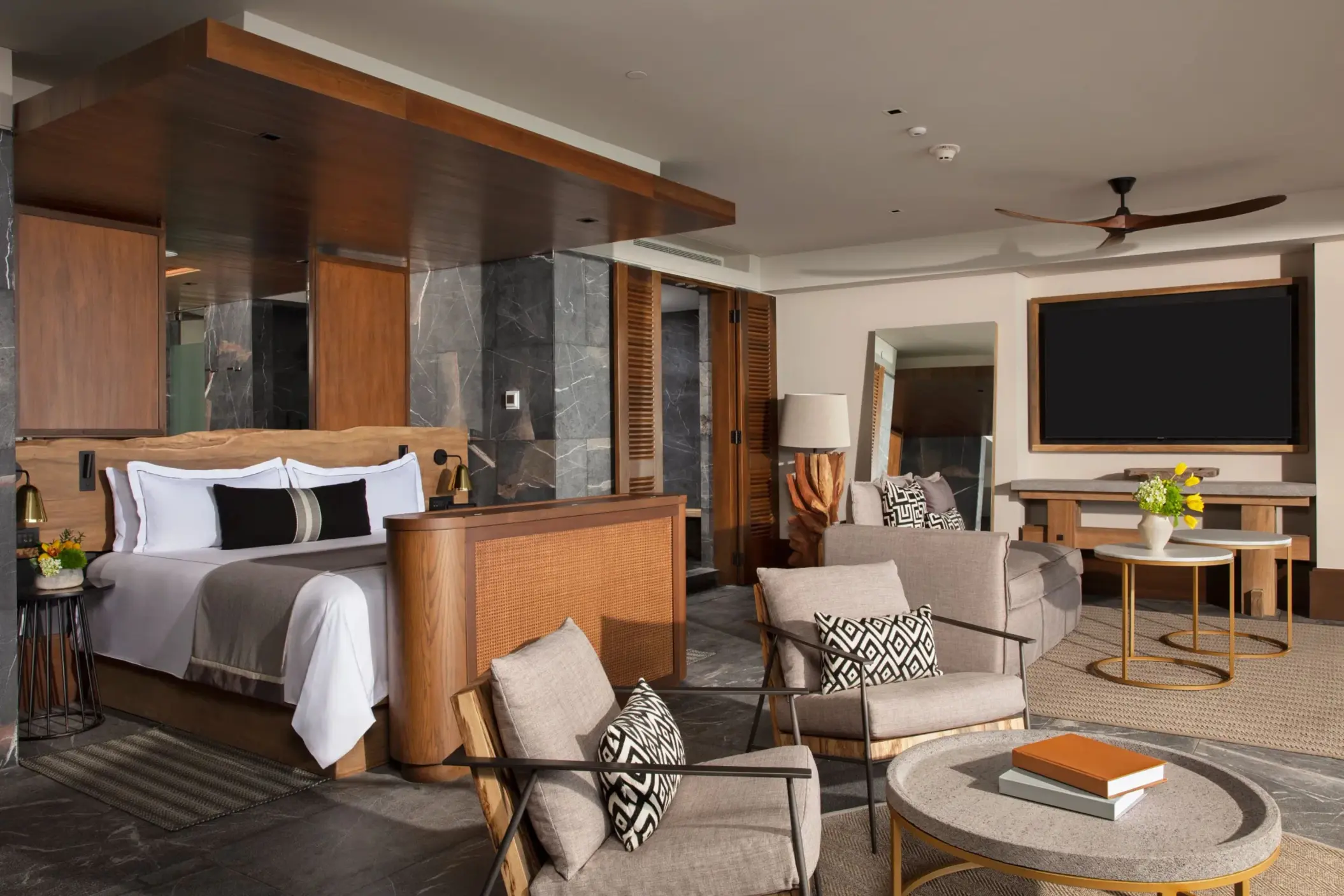 Master suite with king bed, stylish lounge area, and modern wood finishes.