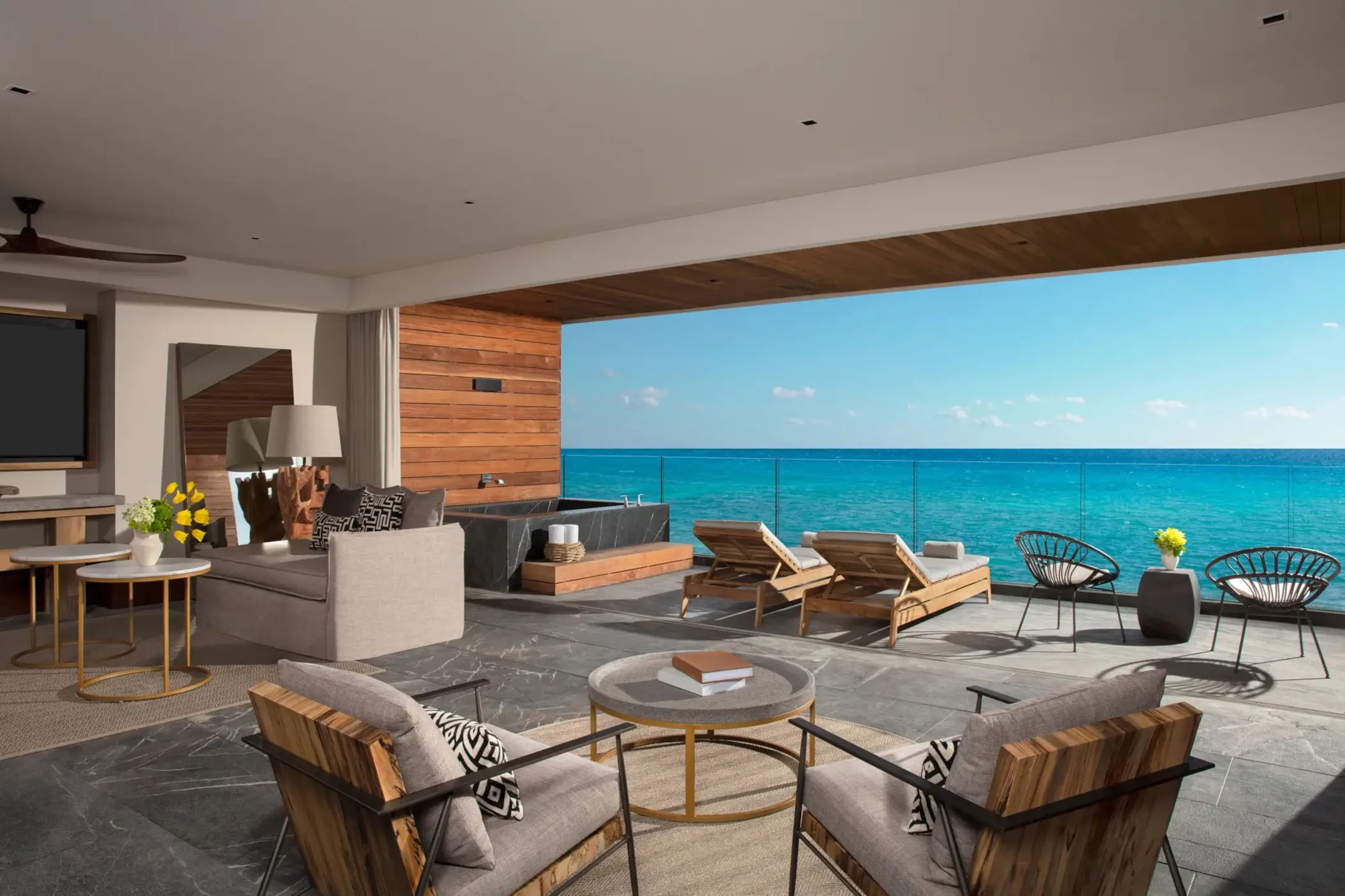 Elegant suite living room with kitchen island and open terrace ocean view.