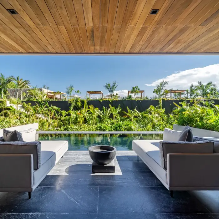 Lush terrace with tropical garden views and shaded lounge seating.
