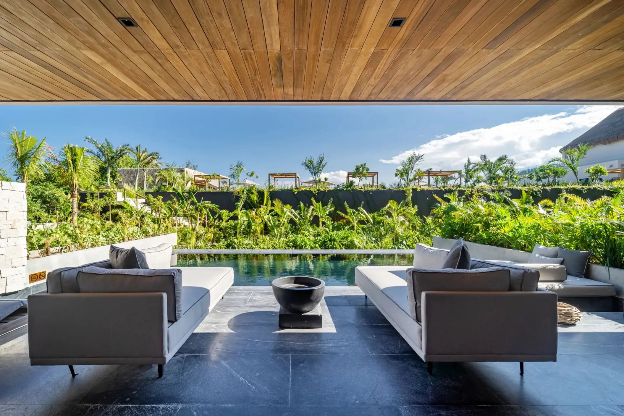 Lush terrace with tropical garden views and shaded lounge seating.