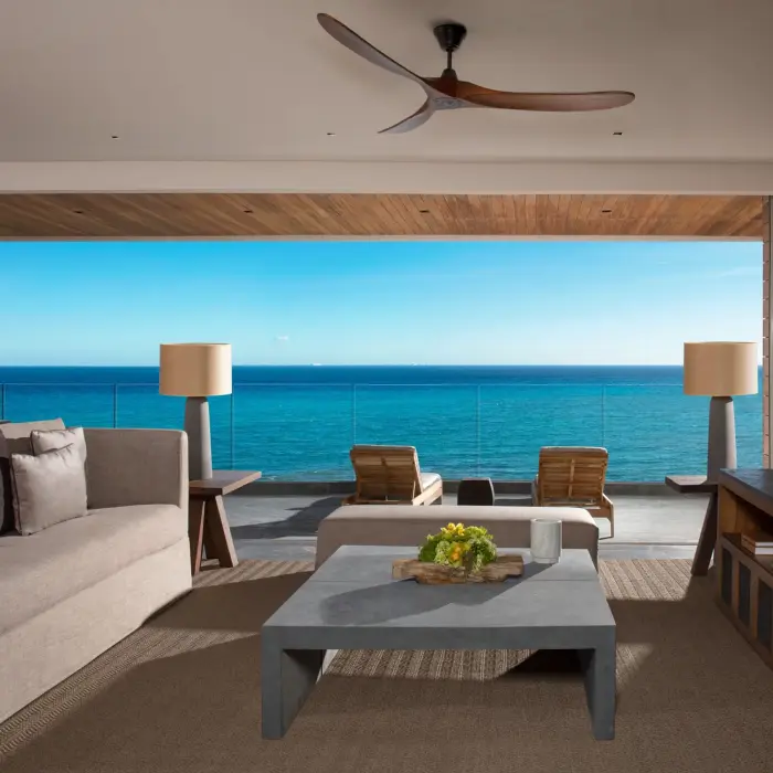Panoramic suite with sofa, modern décor and floor-to-ceiling oceanfront view.