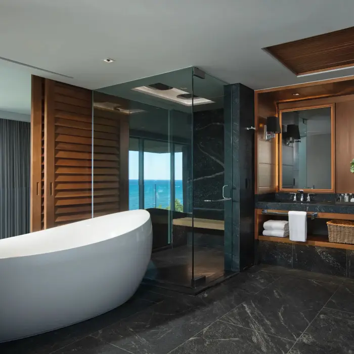 Penthouse bathroom with round tub, glass shower and dual vanity sinks.
