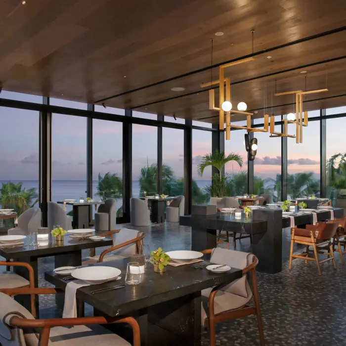 Elegant dining room at Teodoro with ocean sunset views and contemporary lighting at Secrets Impression Moxché.