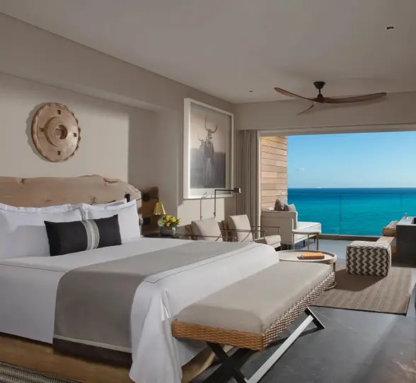 Oceanfront suite with king bed, lounge space, and stunning sea views.