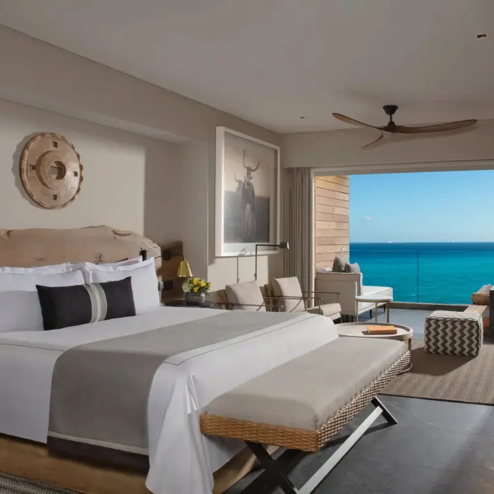 Oceanfront suite with king bed, lounge space, and stunning sea views.