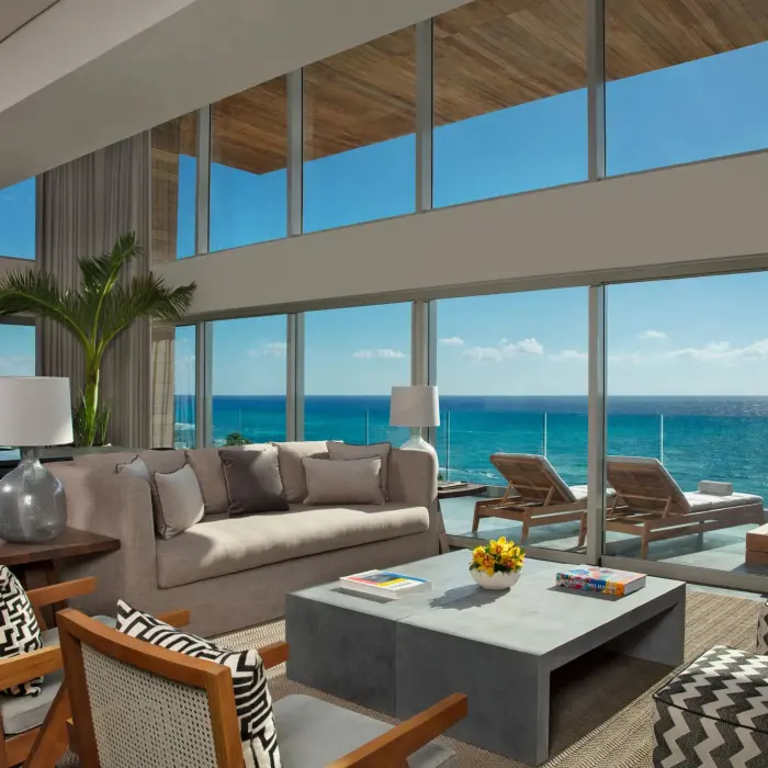 Spacious penthouse living room with floor-to-ceiling windows and panoramic ocean views.