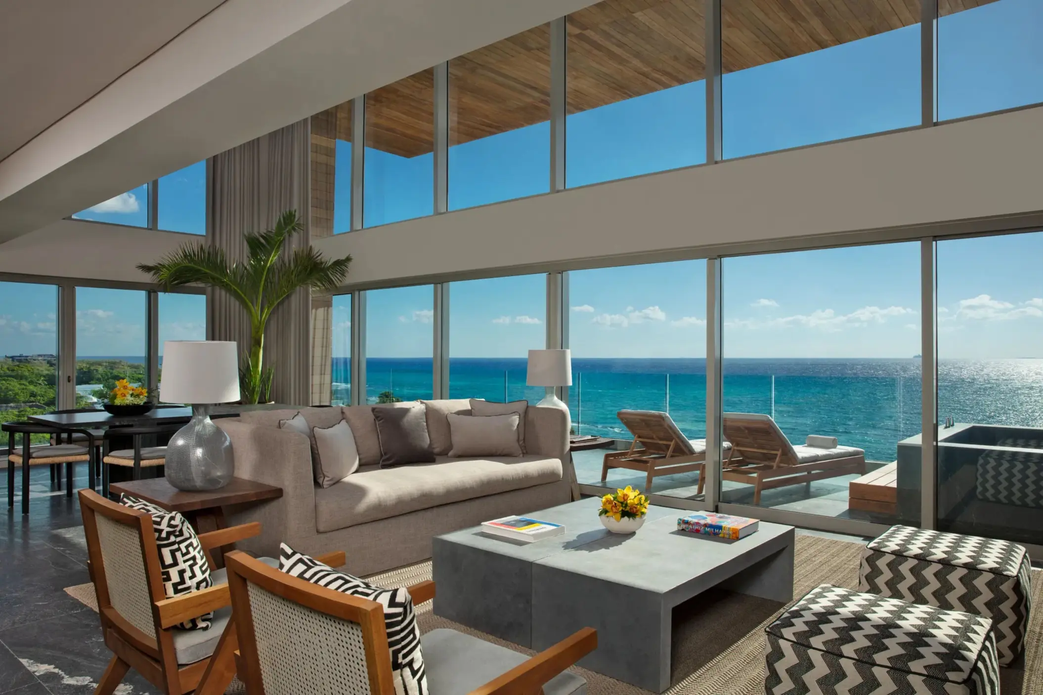 Spacious penthouse living room with floor-to-ceiling windows and panoramic ocean views.