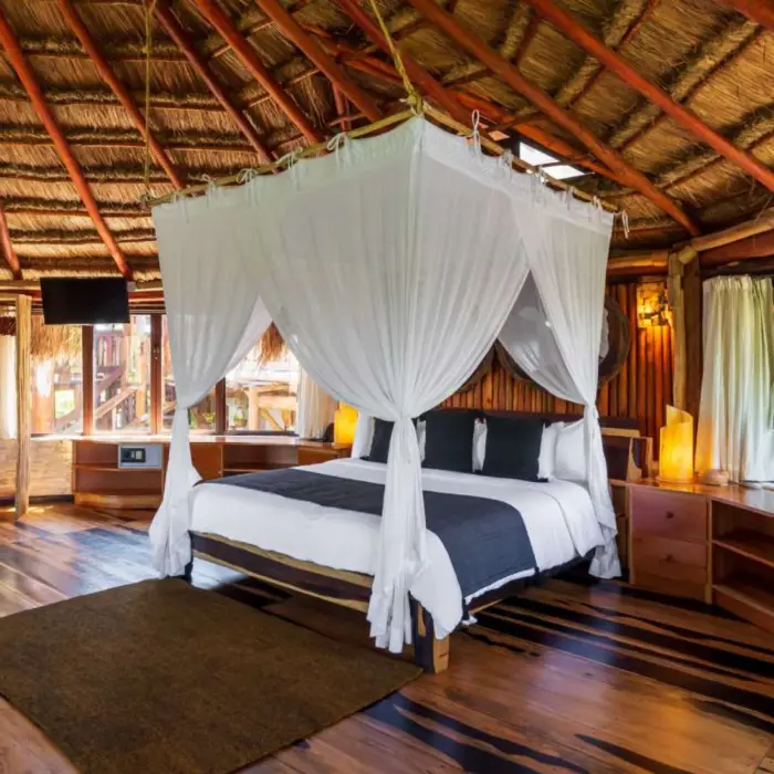 suite at Kanan Tulum Hotel & Spa with king bed and rustic wooden decor