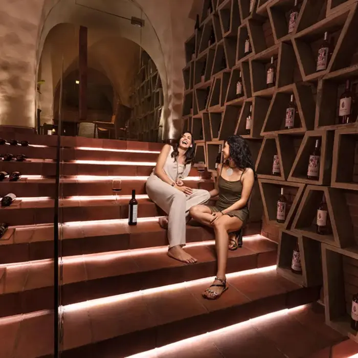wine cellar at La Casa de la Playa with 2 women sitting and chatting