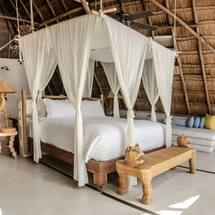 charming room at La Valise Tulum with thatched roof and wooden furniture