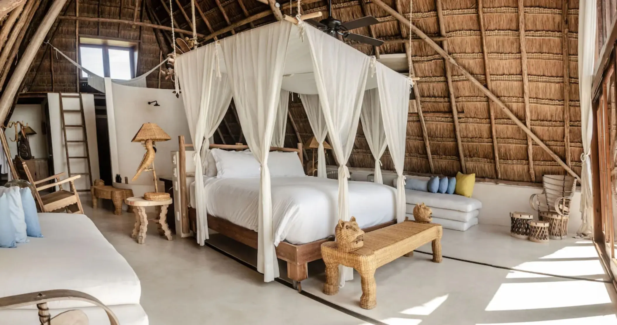 charming room at La Valise Tulum with thatched roof and wooden furniture