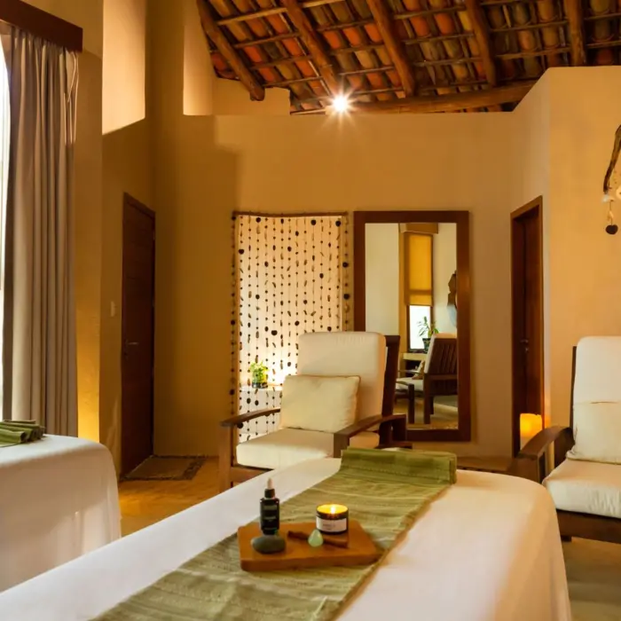 Serene spa room with natural light, wood accents, and two massage beds for a couples' treatment experience.
