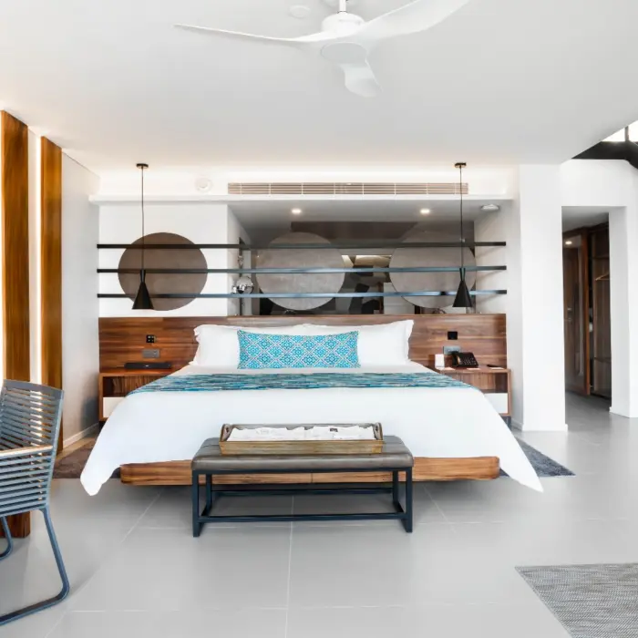 Bright two-story suite with king bed, large mirror decor, and modern wood furnishings.