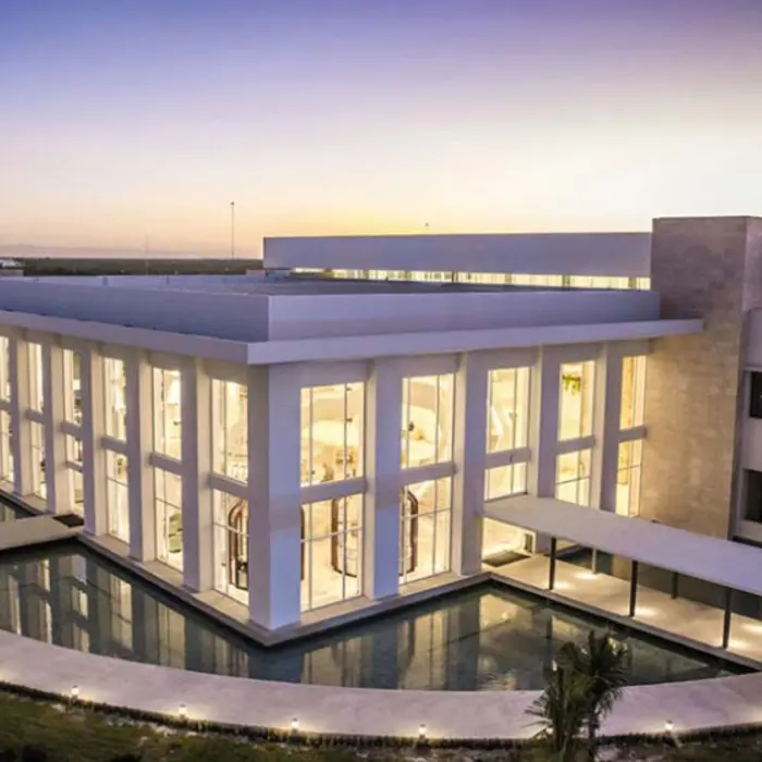 Stunning event venue lit by sunset, surrounded by water and tropical landscaping at Majestic Costa Mujeres.