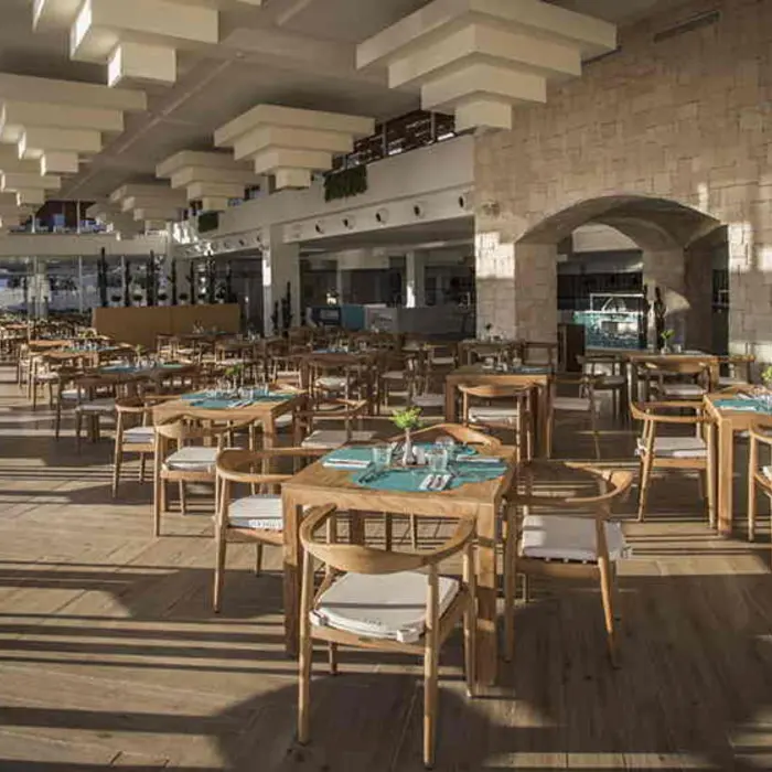 Spacious dining area with wood furnishings, high ceilings, and modern architectural design.