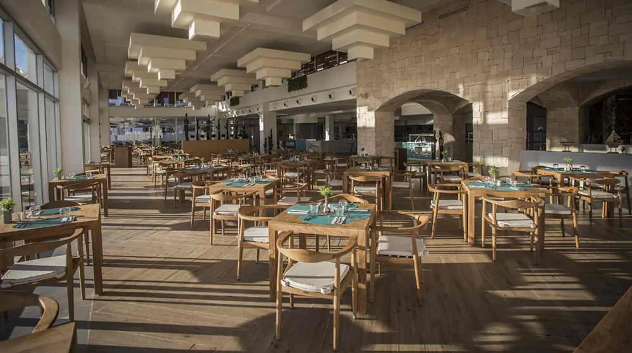 Spacious dining area with wood furnishings, high ceilings, and modern architectural design.