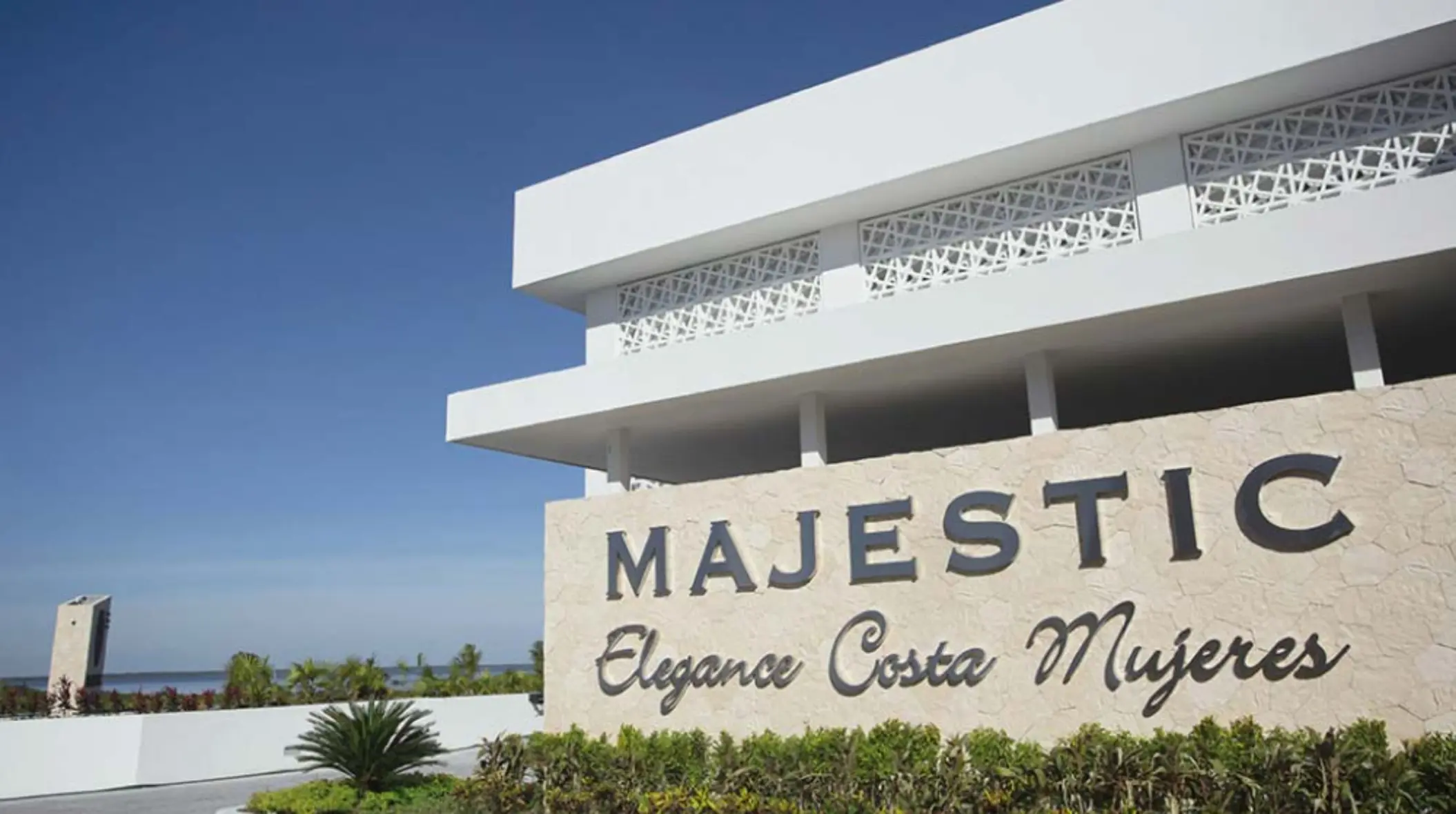 Exterior sign of Majestic Elegance Costa Mujeres against a clear blue sky near the resort’s entrance.