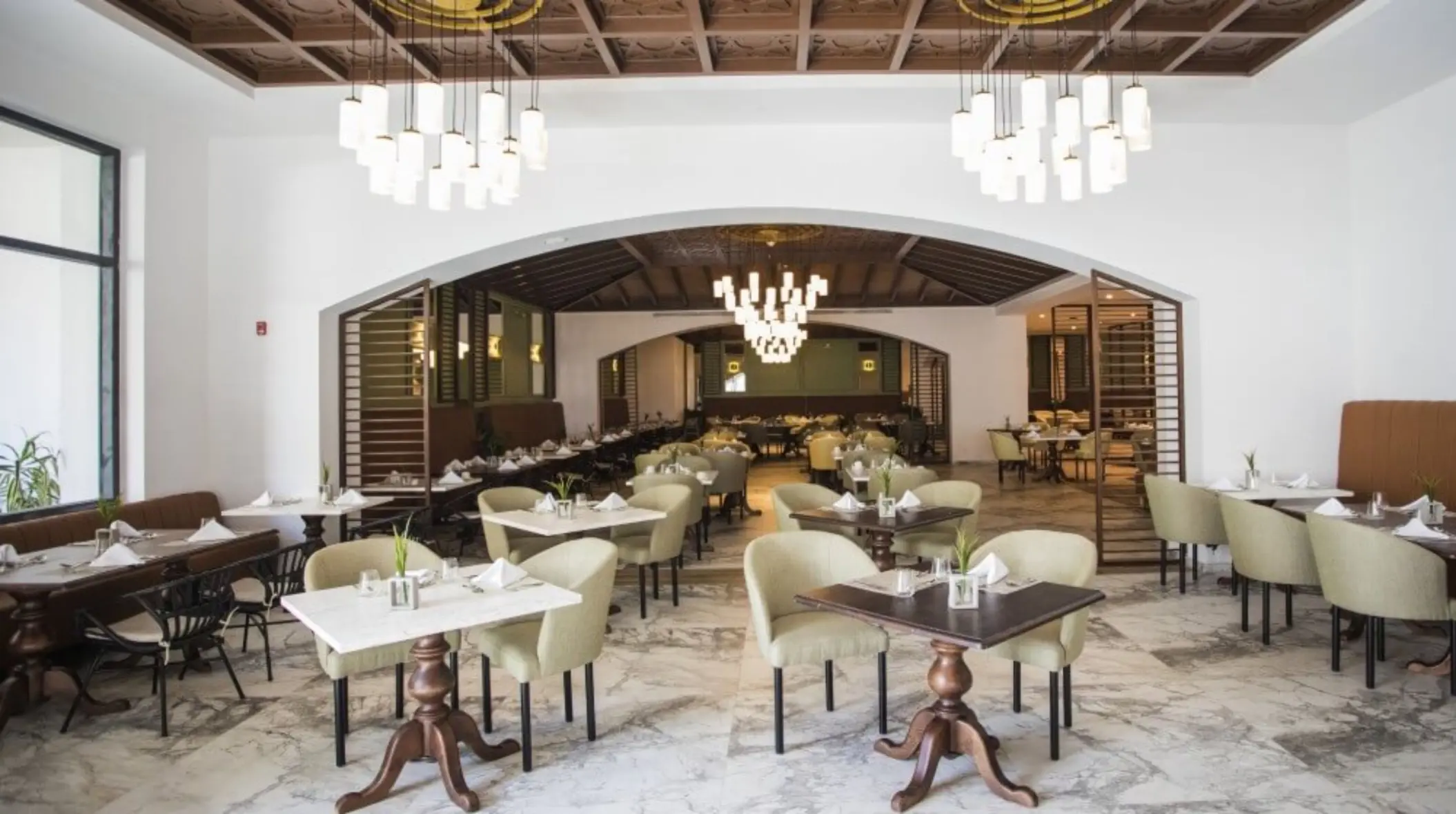 Bright and spacious buffet restaurant with elegant chandeliers, marble floors, and cozy dining areas.