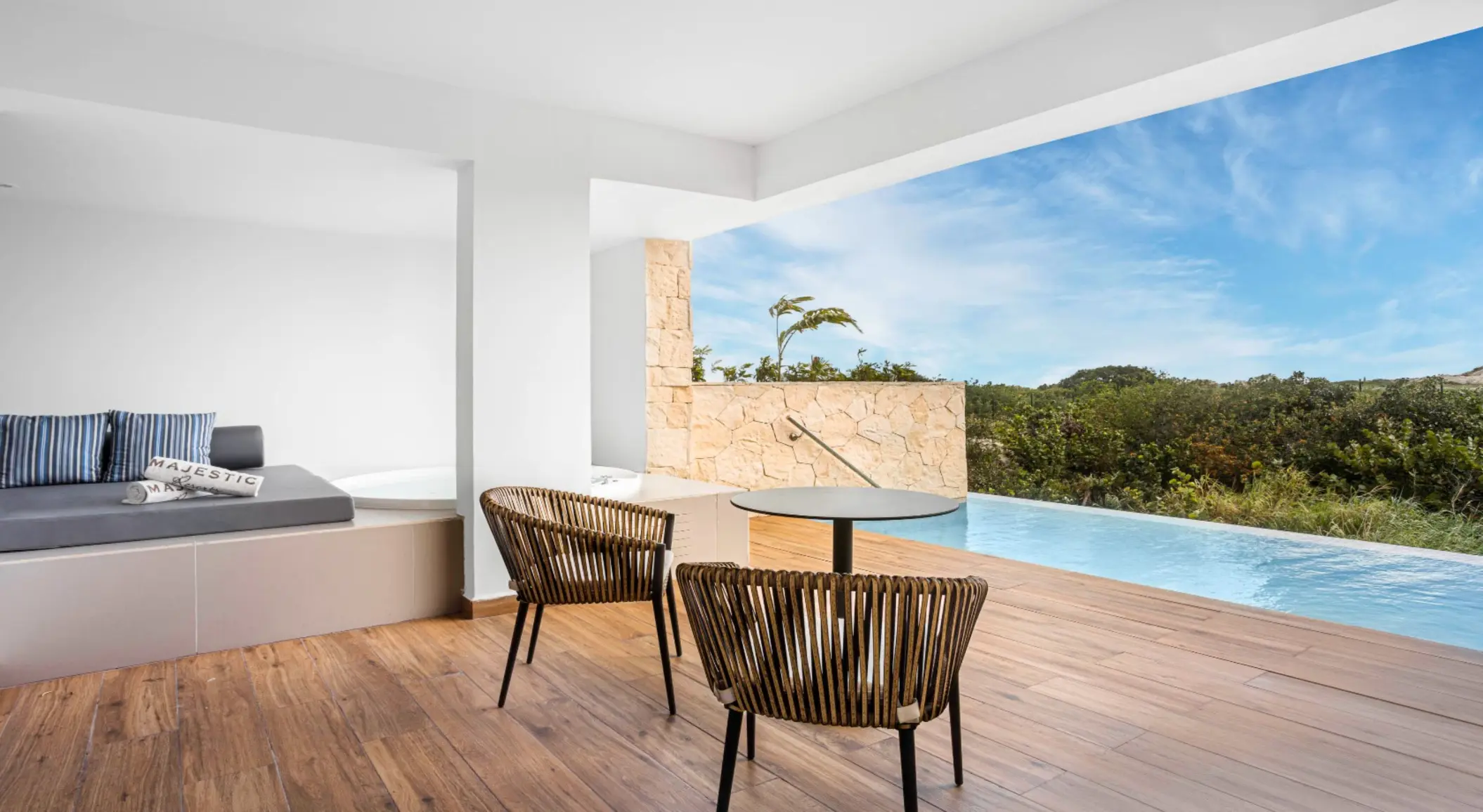 Swim-up suite terrace with loungers, private pool, and garden views at Majestic Elegance Costa Mujeres.