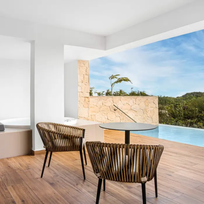 Swim-up suite terrace with loungers, private pool, and garden views at Majestic Elegance Costa Mujeres.