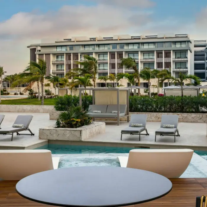 Swim-up suite with modern loungers and direct pool access, overlooking the resort gardens and suites.