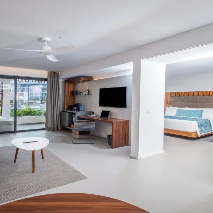 Elegant one-bedroom suite with living room, desk area, and balcony.