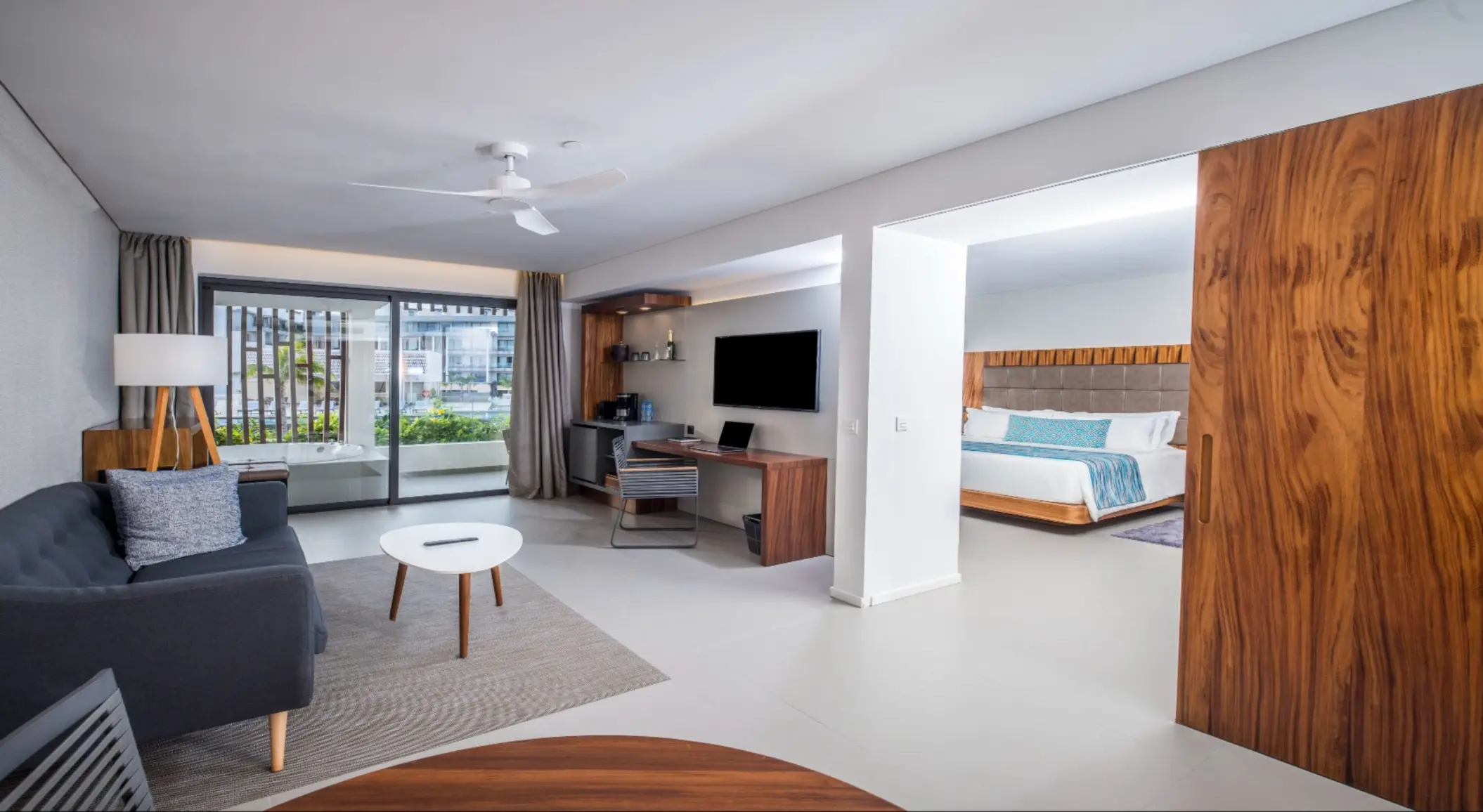 Elegant one-bedroom suite with living room, desk area, and balcony.