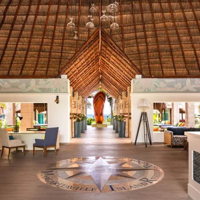 Open-air lobby with thatched roof, ocean views, stylish seating areas, and tropical-inspired design details.