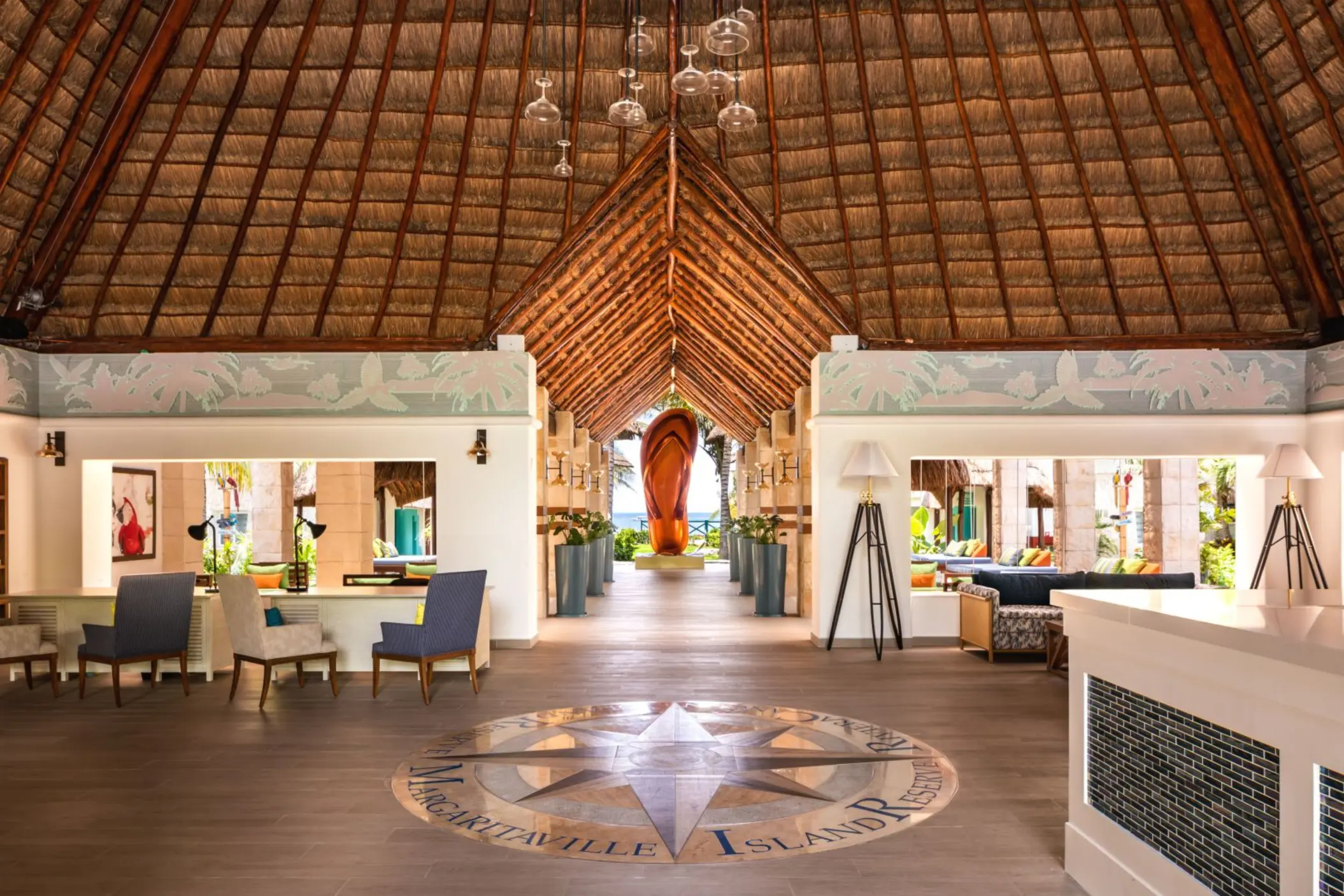 Open-air lobby with thatched roof, ocean views, stylish seating areas, and tropical-inspired design details.