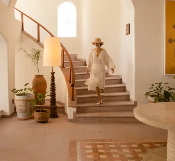 woman walking down the stairs in the lobby of Maroma a Belmond Hotel