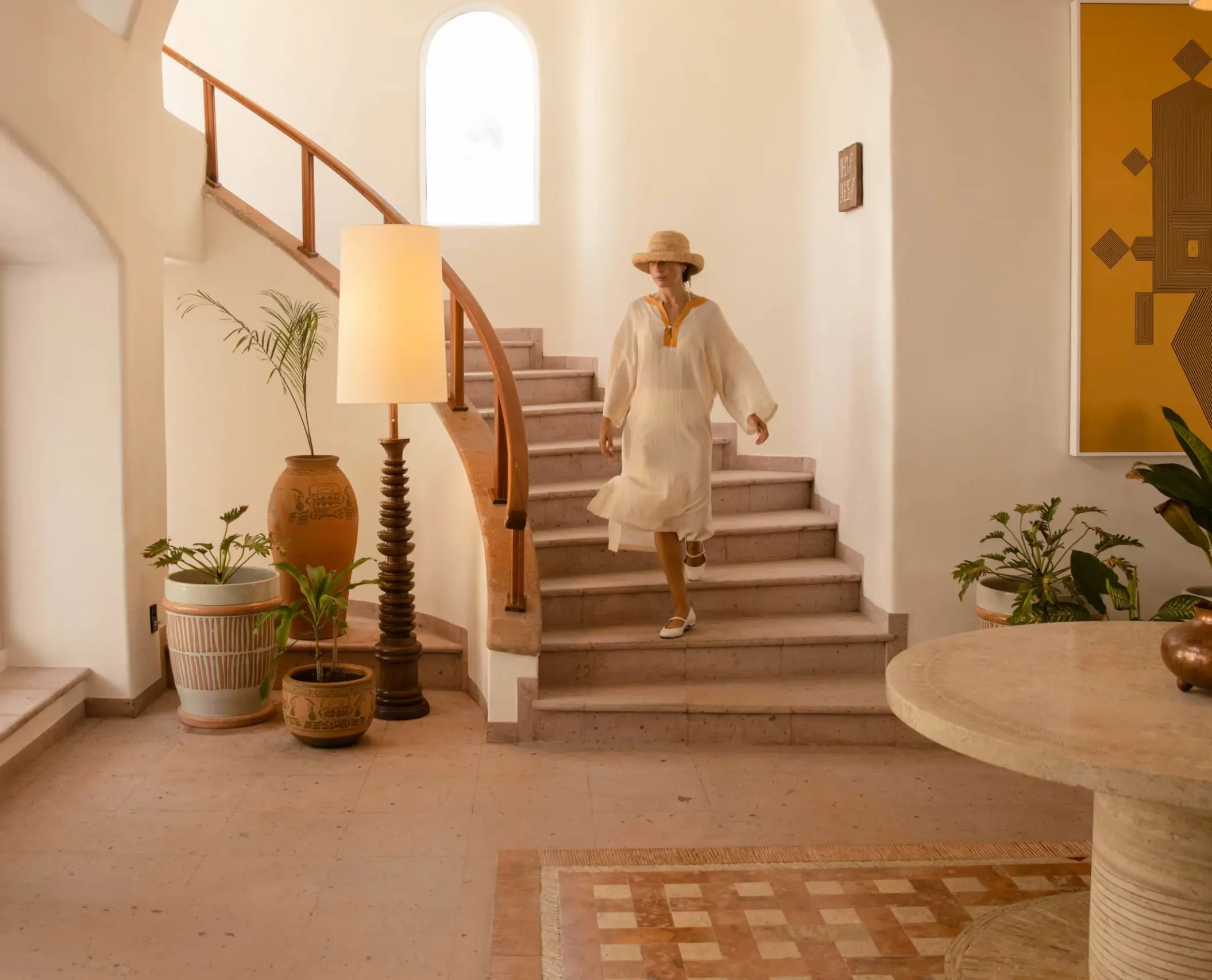 woman walking down the stairs in the lobby of Maroma a Belmond Hotel