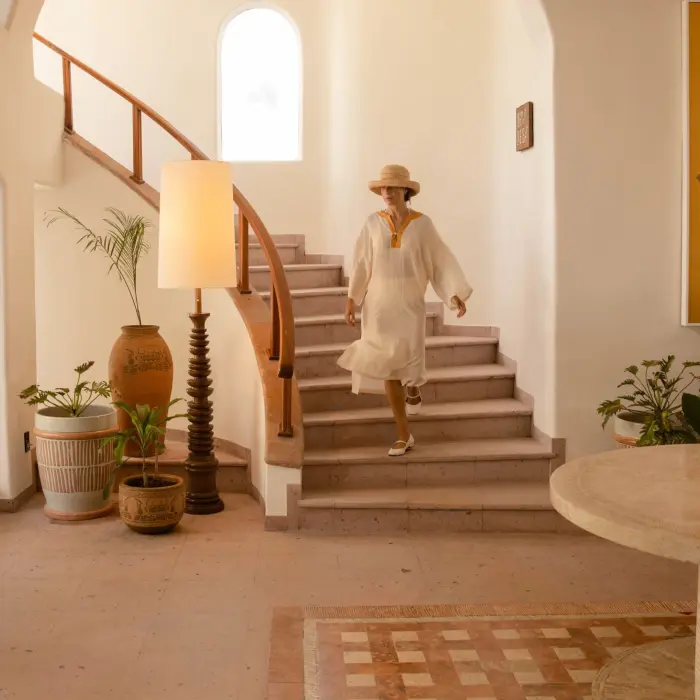 woman walking down the stairs in the lobby of Maroma a Belmond Hotel