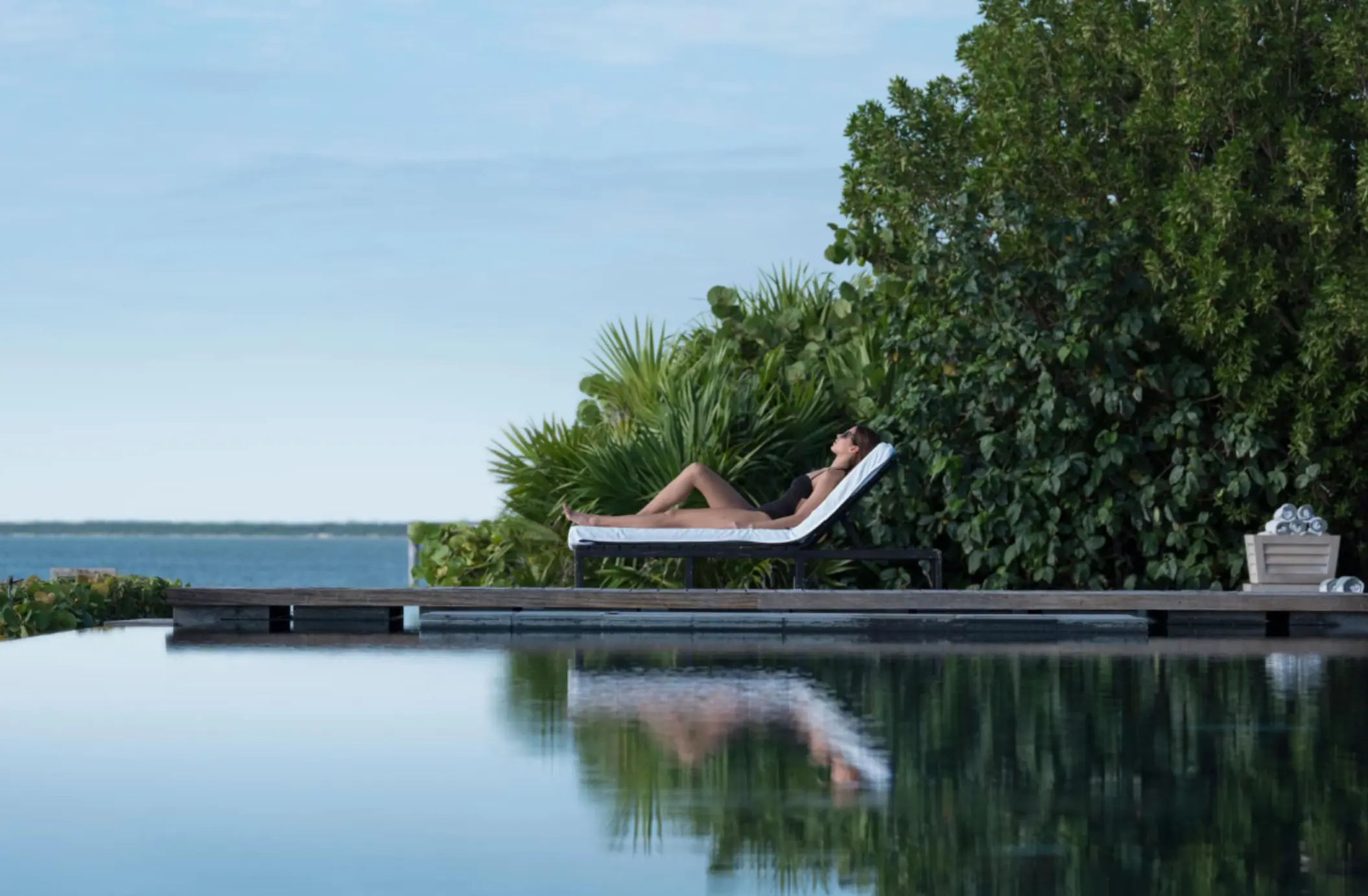 lady lounging by the pool at Nizuc Resort and Spa