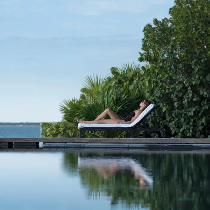 lady lounging by the pool at Nizuc Resort and Spa