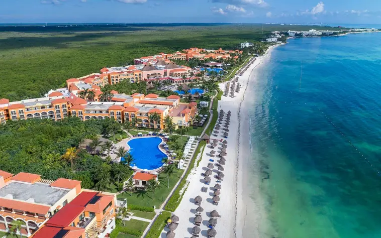Aerial view of the extensive resort, showing the buildings, multiple pools, and a long beach.